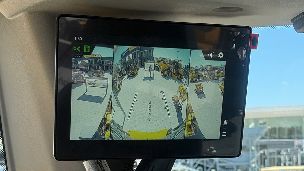 In-cab display guides a John Deere motor grader operator during grading on a construction site.