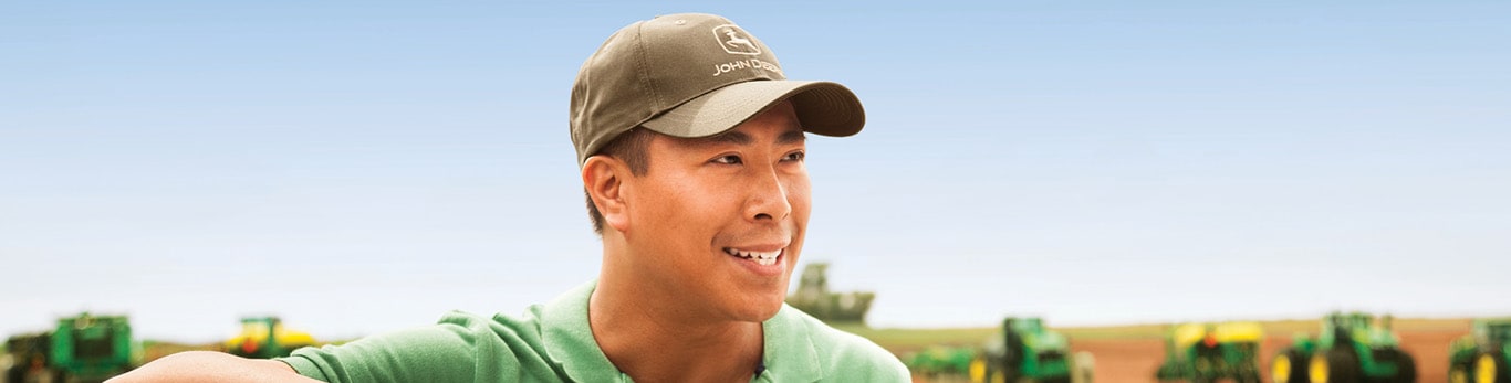 Person standing in field with products in the background.