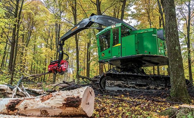 John Deere 859mh tracked harvester with IBC working in forest.