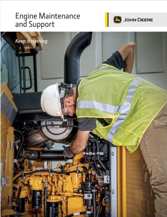 A person in a hardhat and yellow vest working on an engine