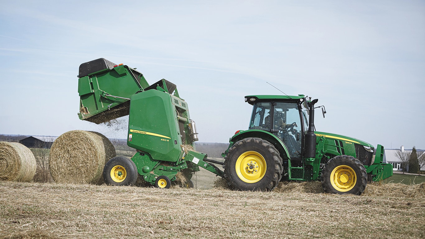 5 Series Tractor dumping a hay bale in a field