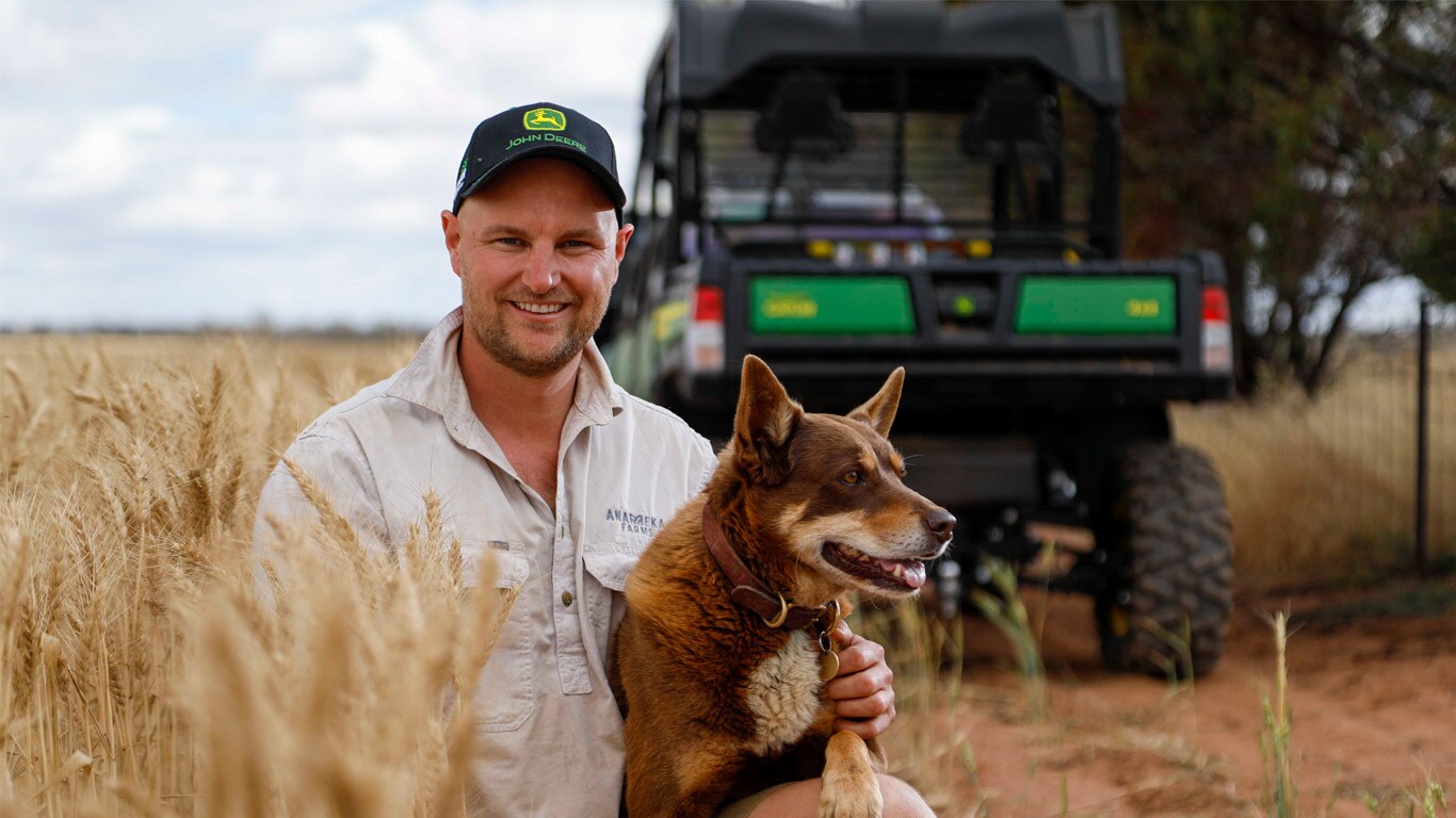 WA farmer Oscar York with his dog in wheat paddock
