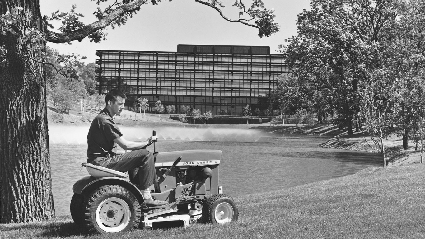 Historical black and white image of a man on old riding lawn equipment (RLE)