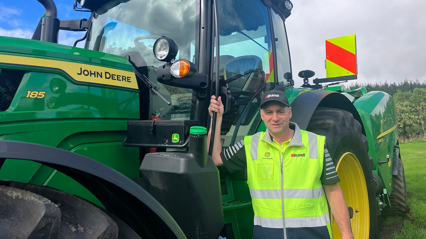 Bryce Dickson next to his 185 John Deere tractor