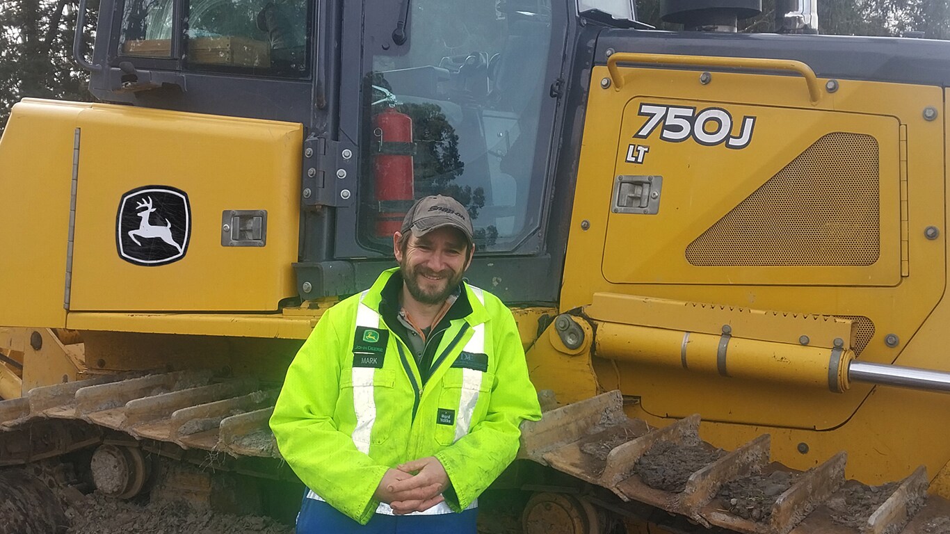 Mark Haughton next to his John Deere 750J LT
