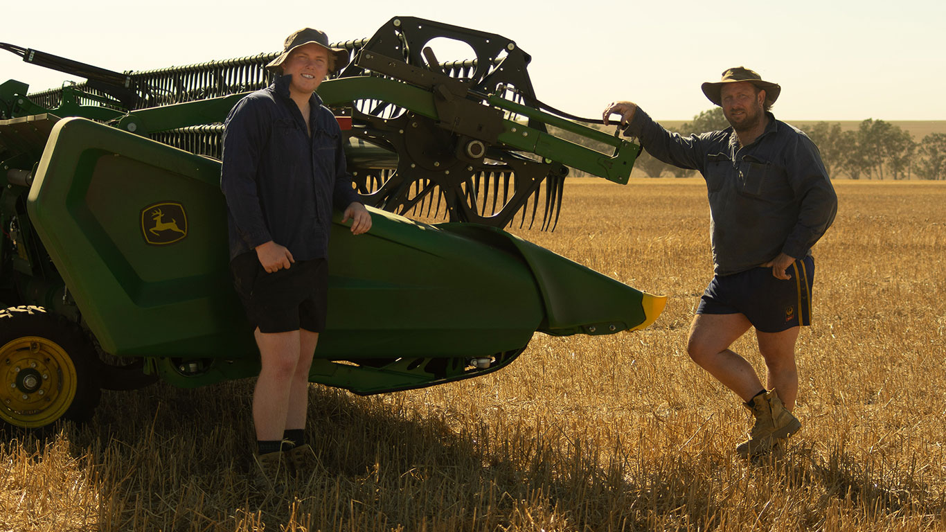 Daniel and Jack Winter in a paddock at the front of their X9 Combine.