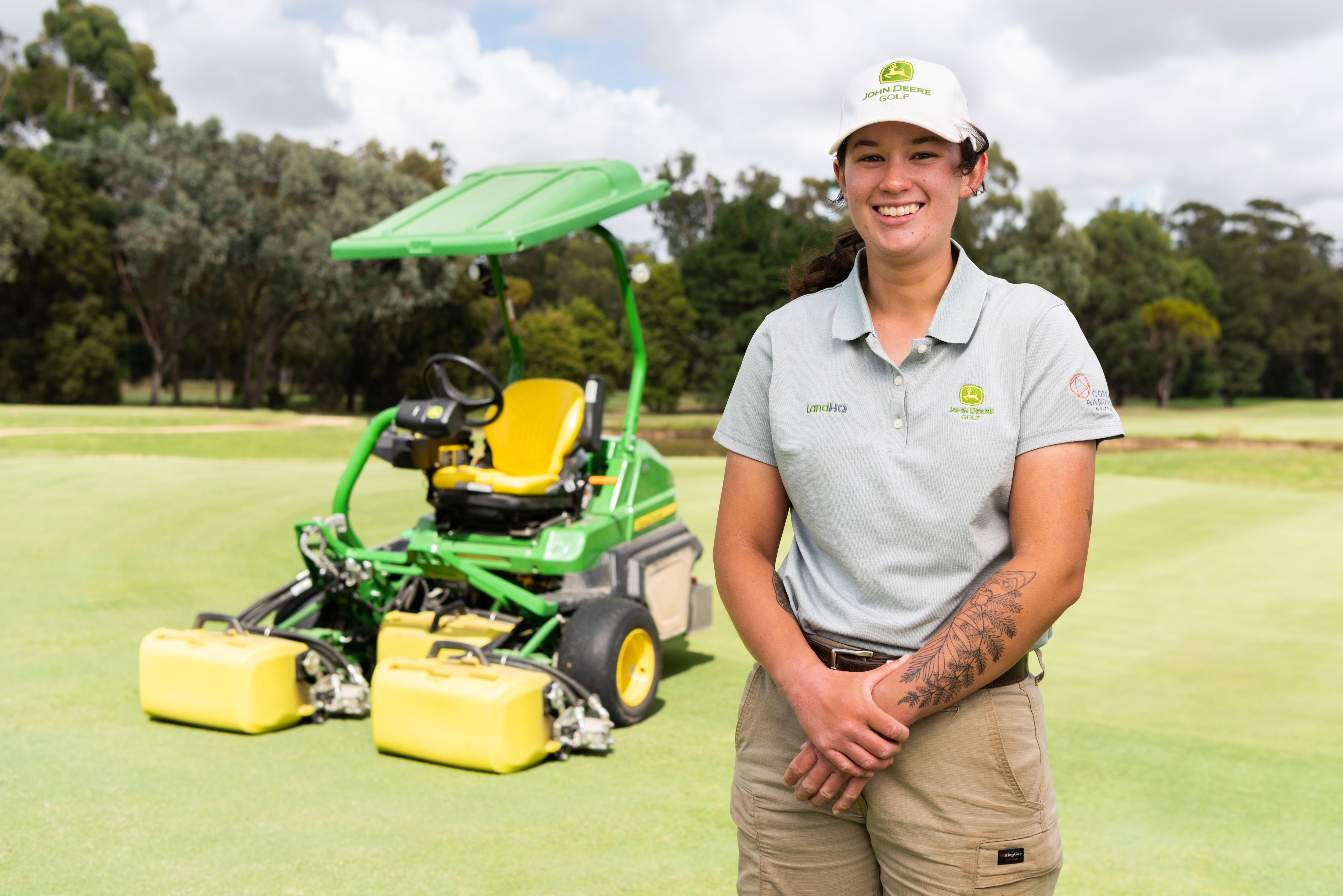 Annabelle Southall standing in front of a John Deere Golf Mower