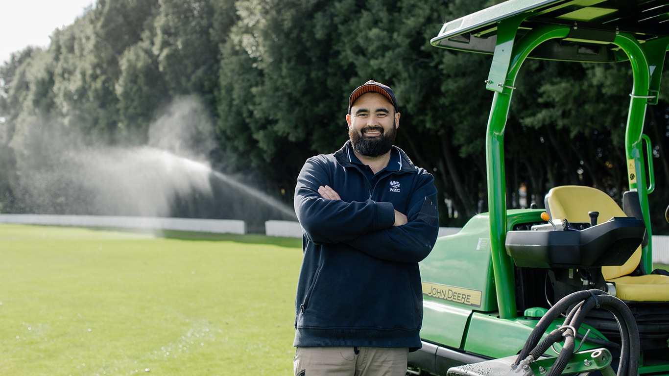 Steve Tsukigawa, Turf Manager stands in front of his fairway mower