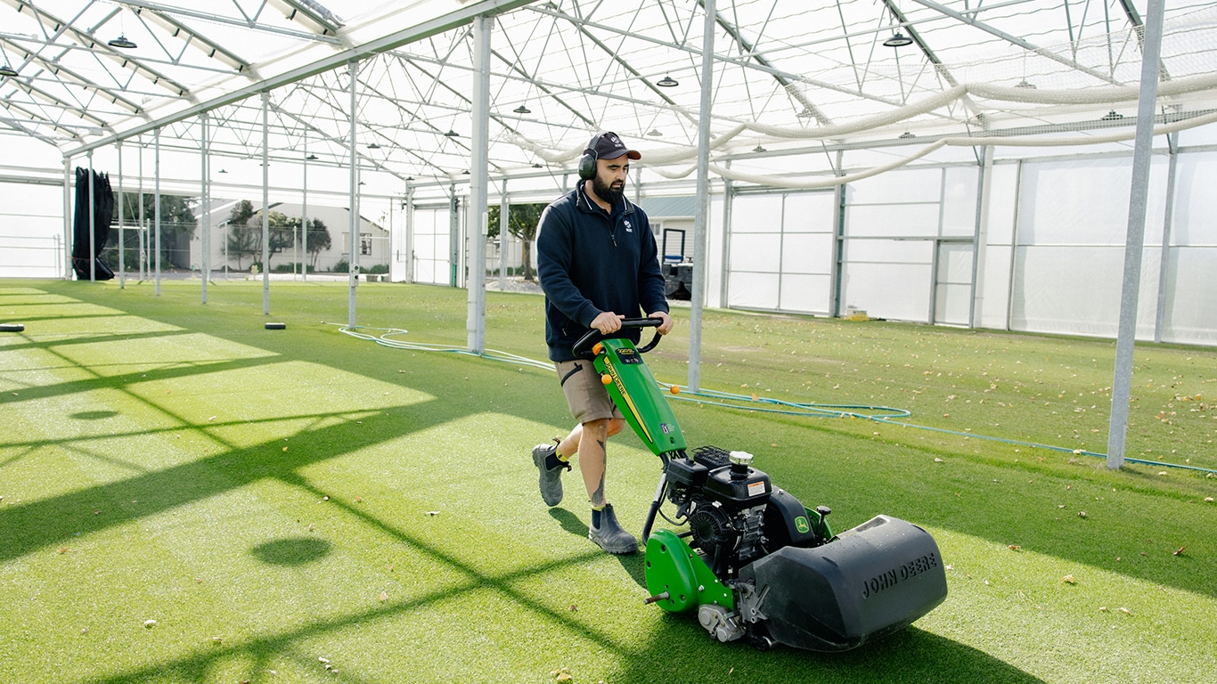 Steve using his John Deere 220SL PrecisionCut™ Walk Greens Mowers to maintain the pitches inside the 18-pitch semi-indoor training facility.