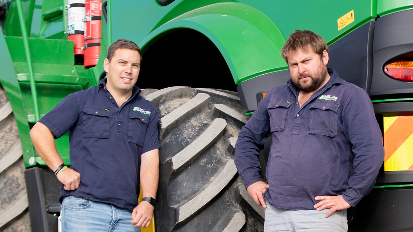Phil and Tim May in front of a John&nbsp;Deere machine