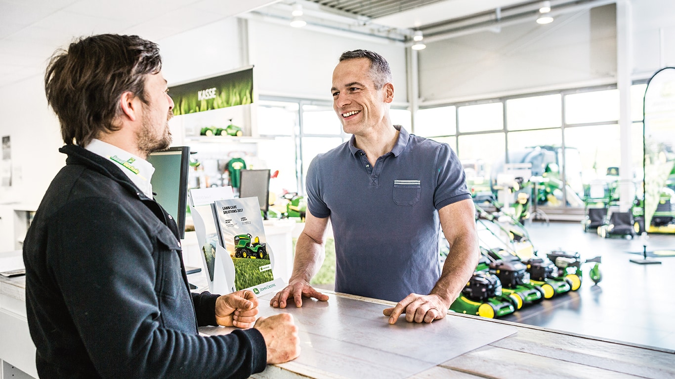 two men talking over a sales counter