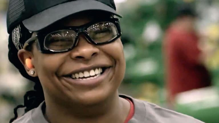 Close up of female factory worker smiling.