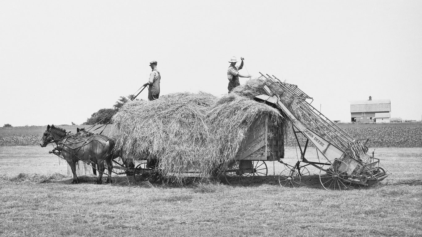 Black and white photograph of John Deere equipment in a field