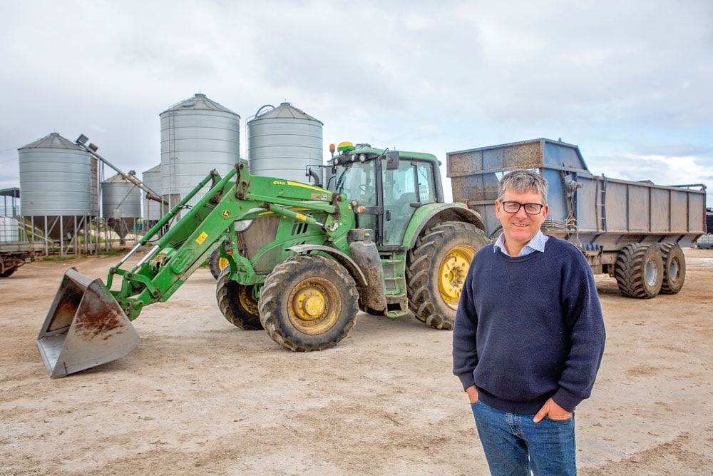 Dairy farmer in front of John Deere equipment