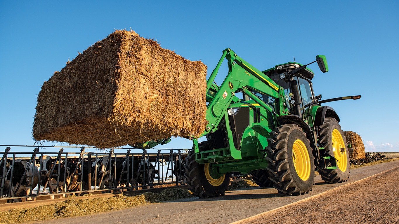 New 7R 210 with loader and a bale of hay