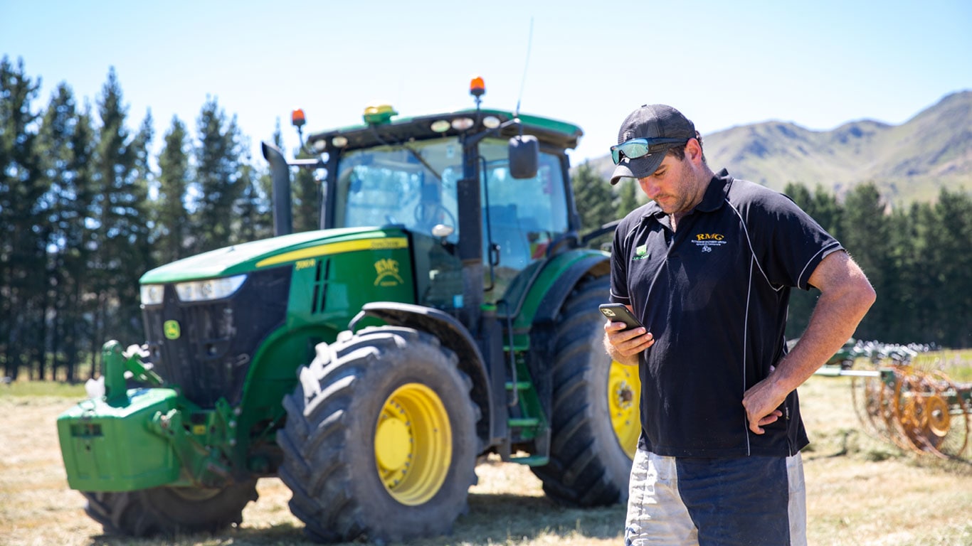 John Ranford looking at a mobile device in front of equipment