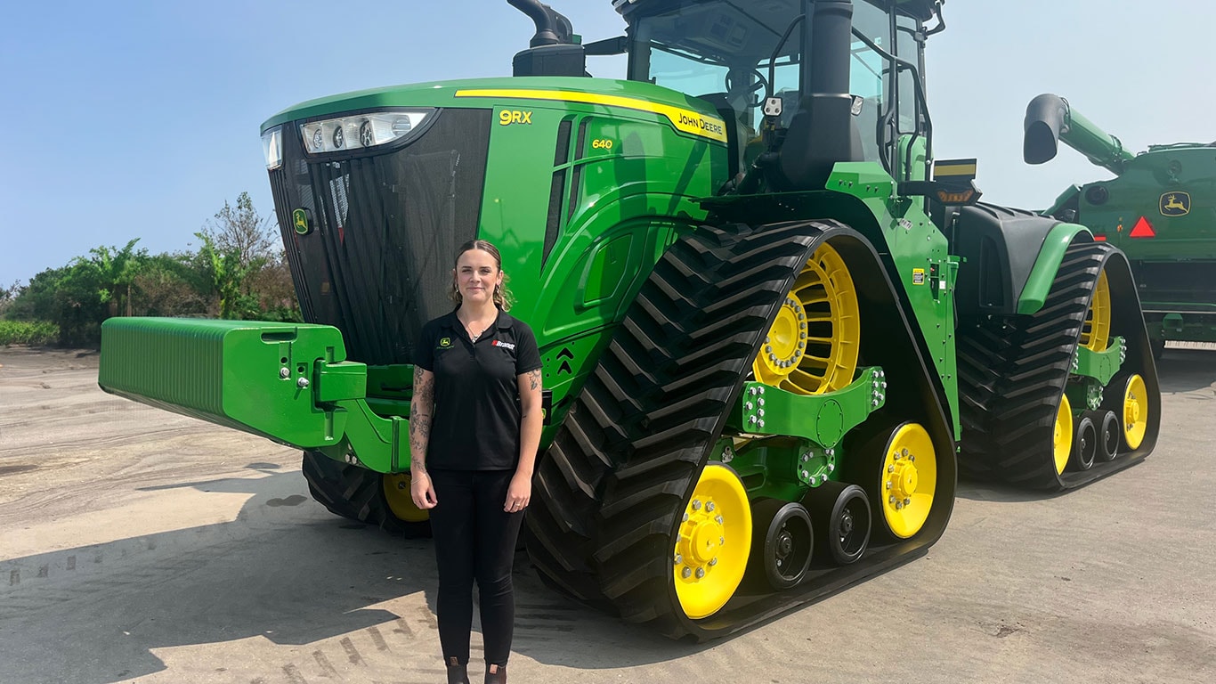 Mollie Clarke in front of John Deere equipment