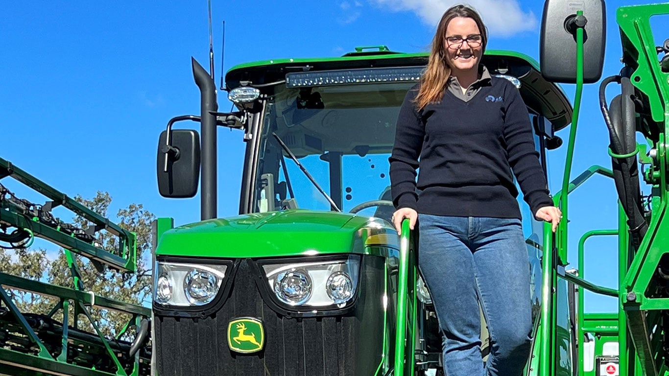 Lauren Cortes in front of John Deere equipment