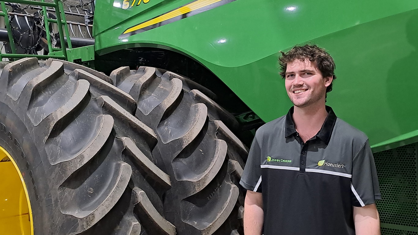 Lachlan Corridan posing in front of John&nbsp;Deere equipment