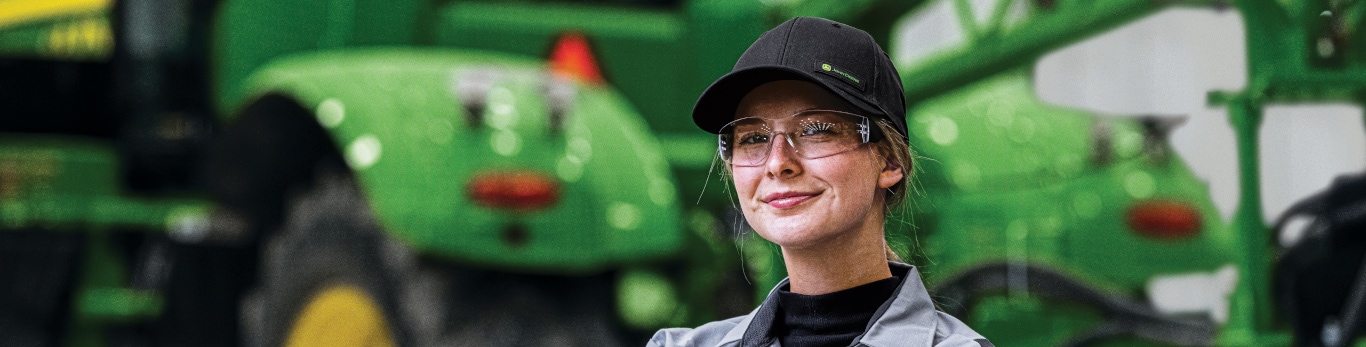 Woman crossing arms in front of tractor