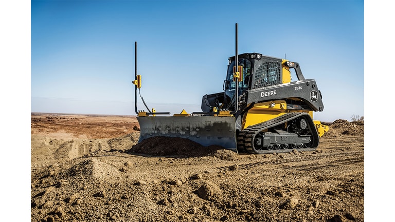 A 333G Compact Loader with Level Best Box Blades attachment grade dirt at a worksite.