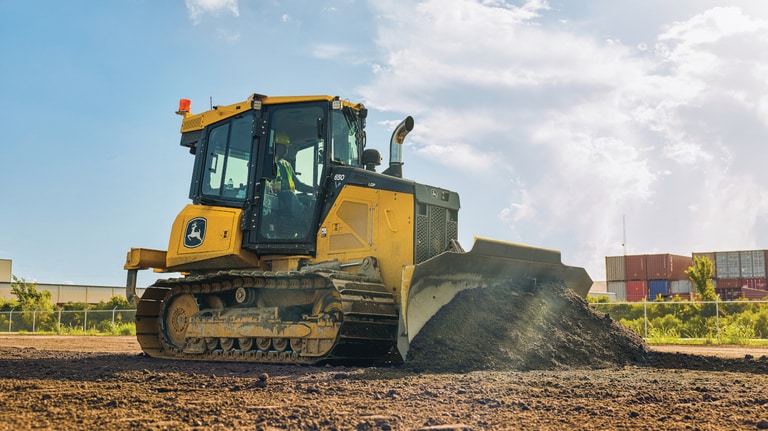 Right-side view of a 650P Dozer pushing dirt at a worksite.