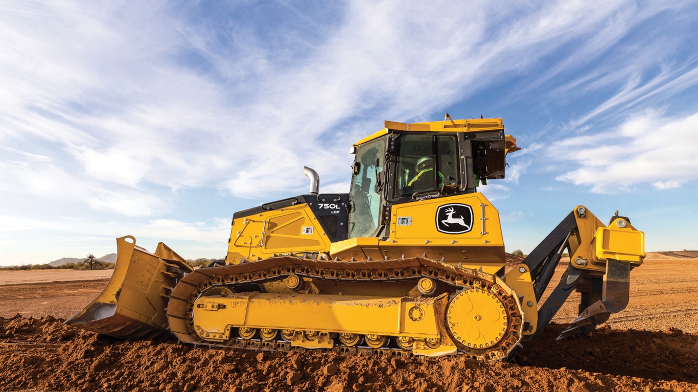 Side view of a 750L Dozer pushing dirt on a worksite.
