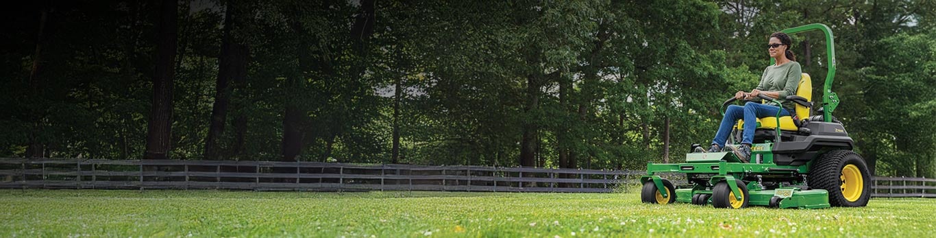 A woman mowing her lawn with a John Deere Z760R ZTrak&trade; Zero-Turn Mower.