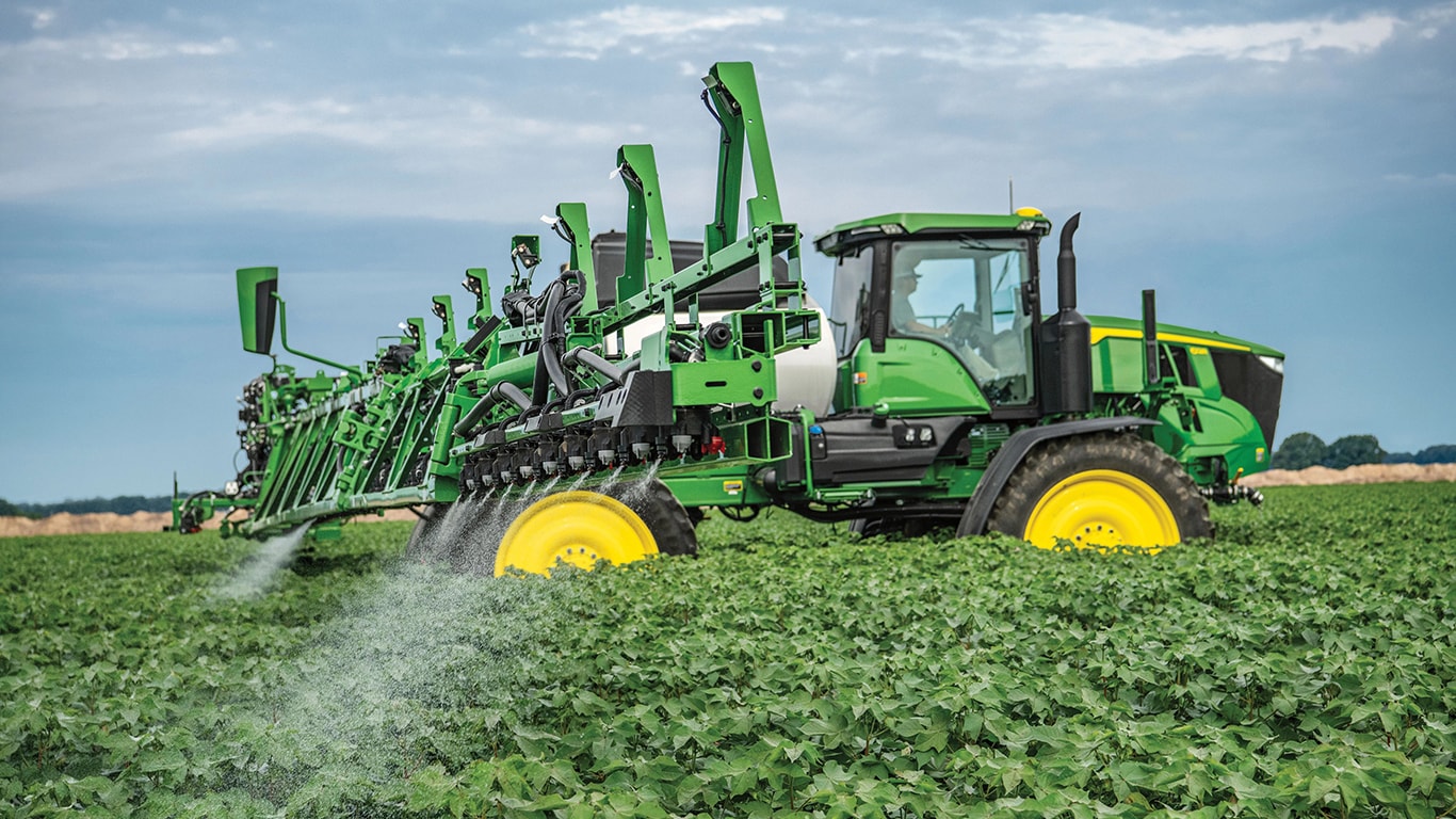 A John Deere 600 Series Self-Propelled Sprayer in a cotton field.