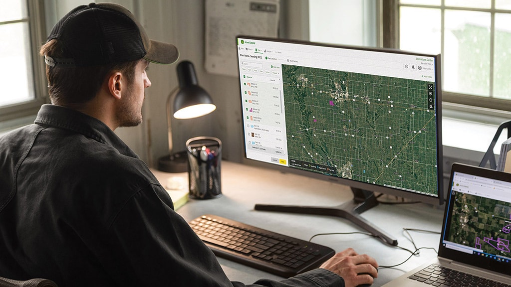 Man on John Deere Operations Center on desktop computer