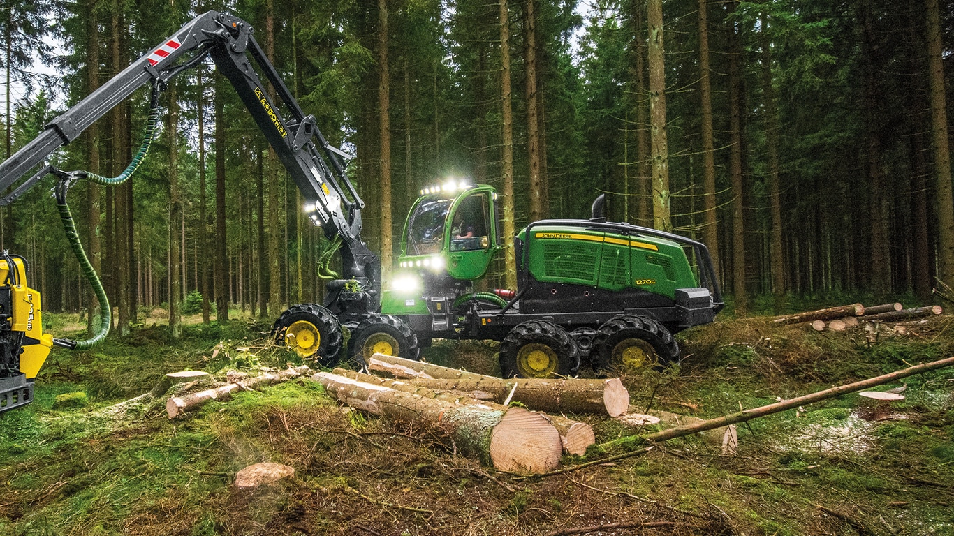 1270g wheeled harvester moving tree trunks in forest