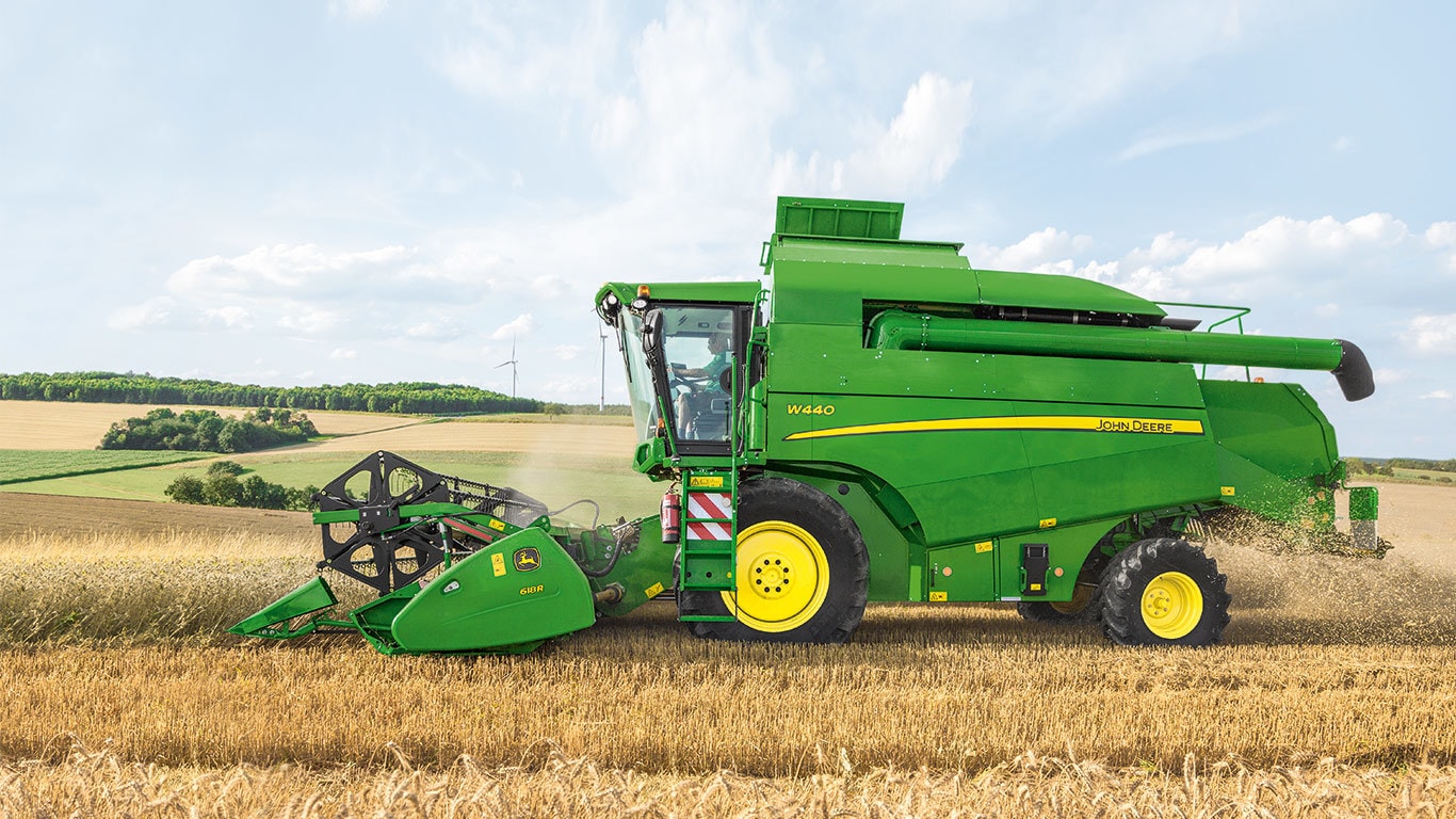 A combine going through a wheat field