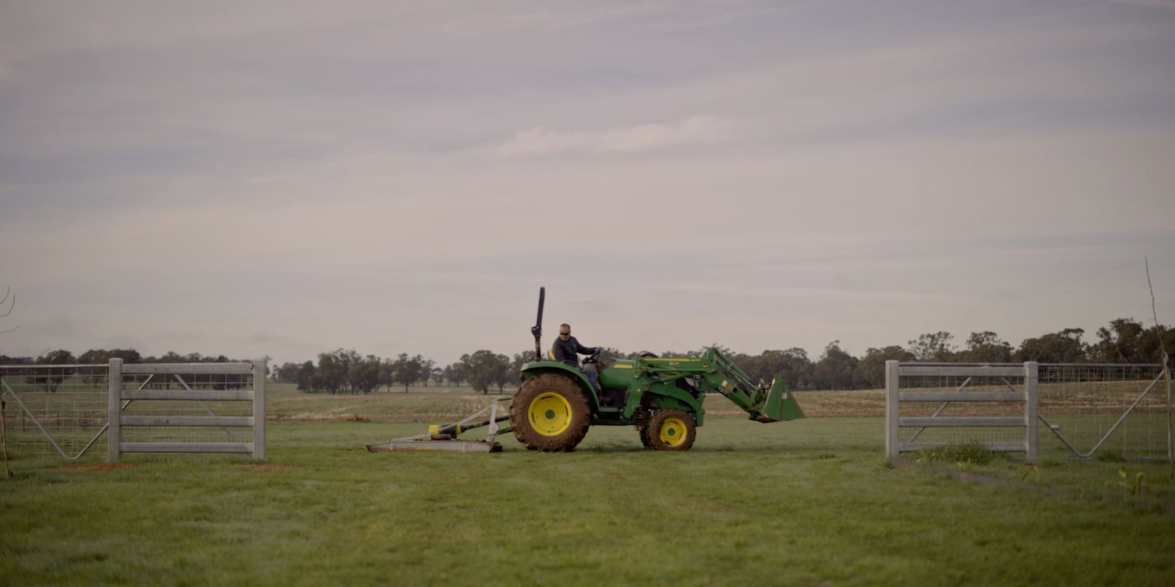 A John Deere utility tractor in the middle of a paddock