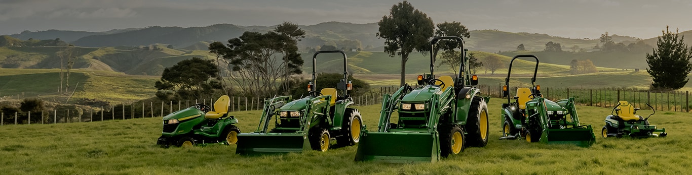 Various lawn tractor models in a field during sunset