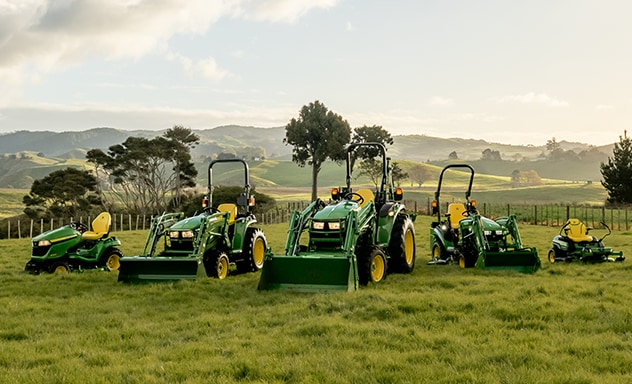 Various lawn tractor models in a field during sunset