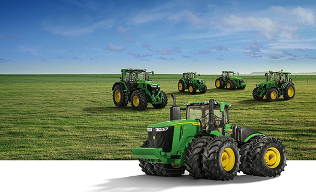 Tractors in an open field of grass, with a 9R 640 Tractor in front of them
