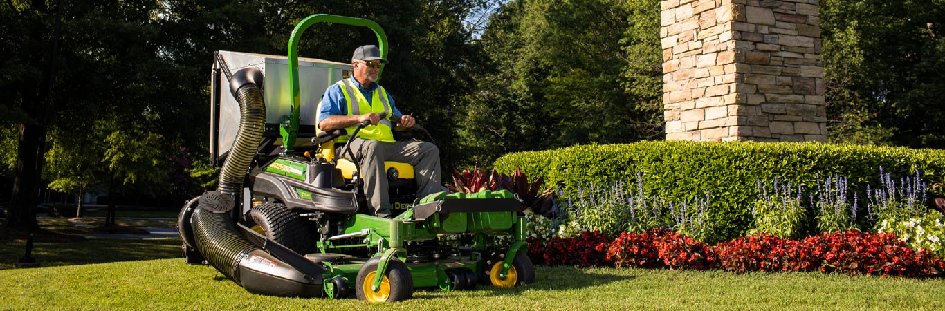 Landscaper mowing grass using a riding mower