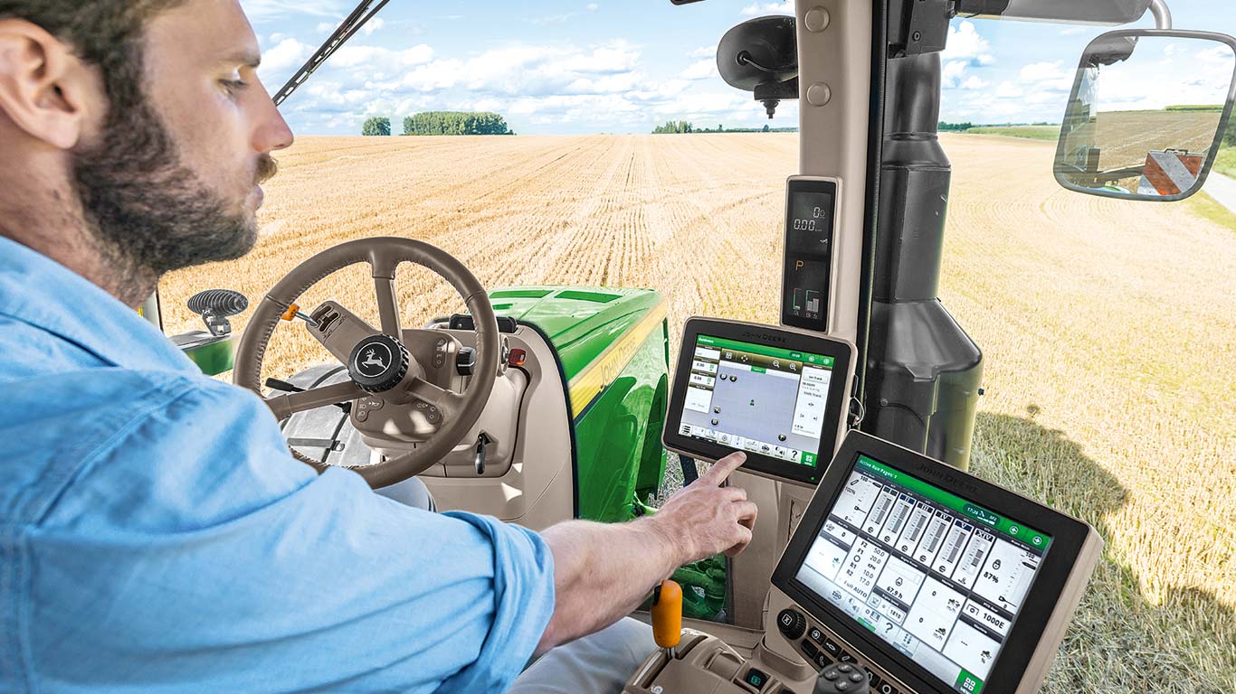 Farmer using John Deere Precision Agriculture computer in a tractor.