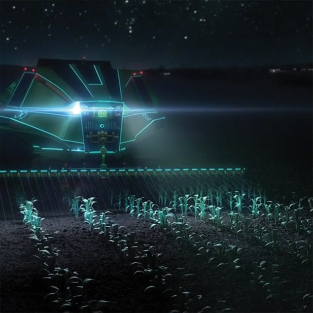 Futuristic John Deere machine fertilizing crops at night