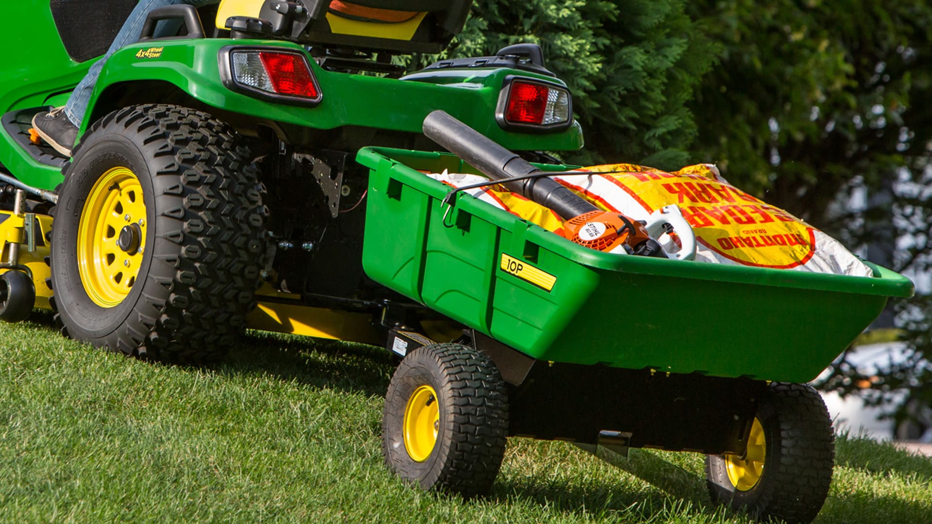 Closeup shot of a ride-on mower pulling a cart