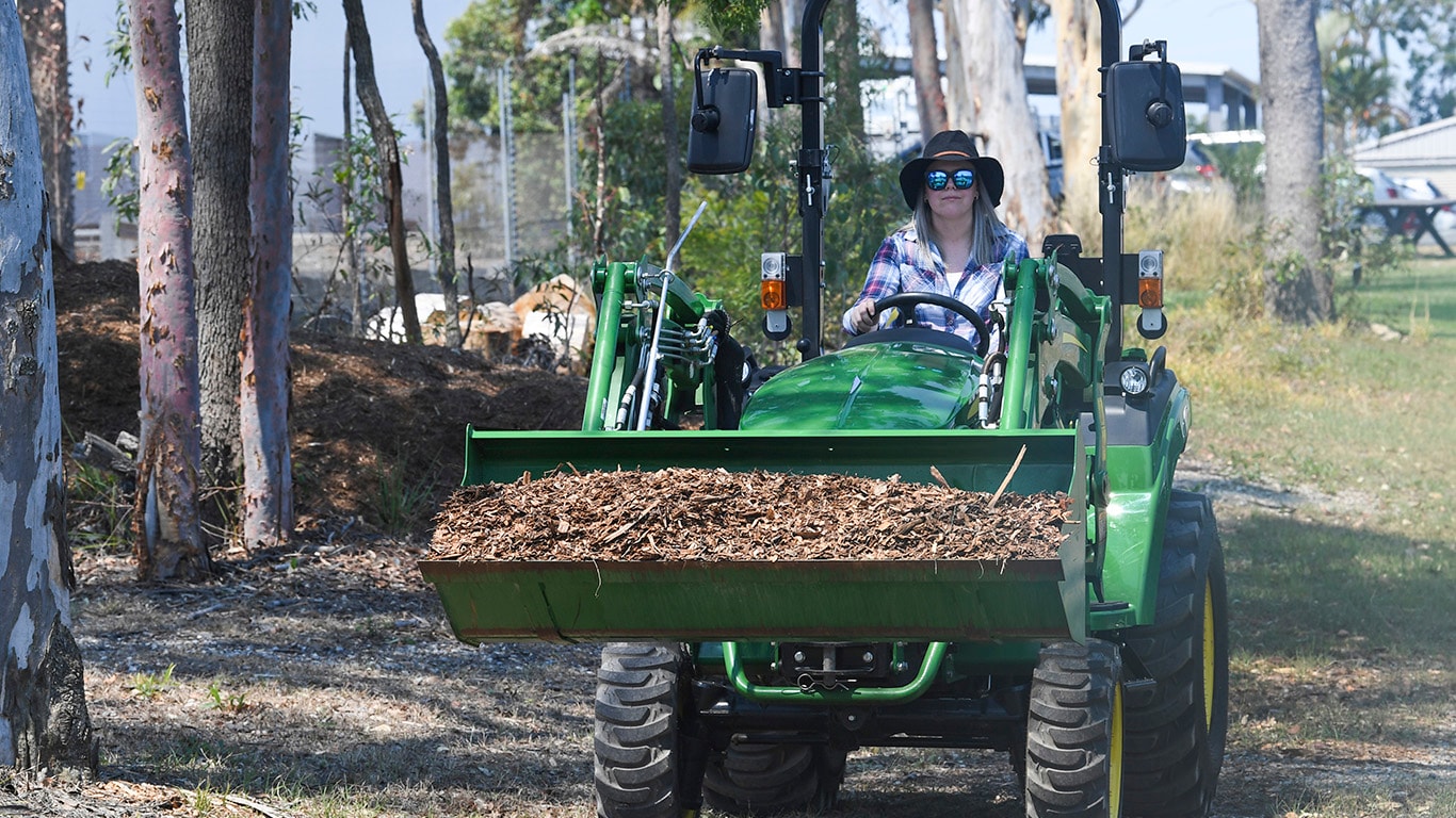 woman driving tractor with loader