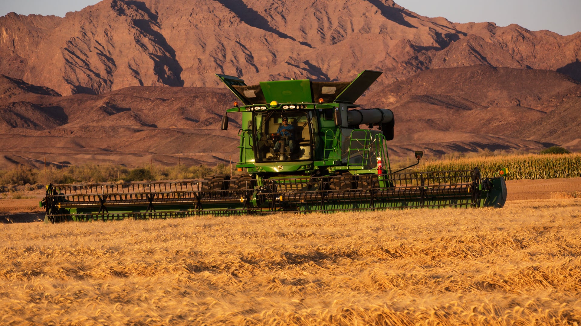 draper platform image of machine moving through field with mountains in background