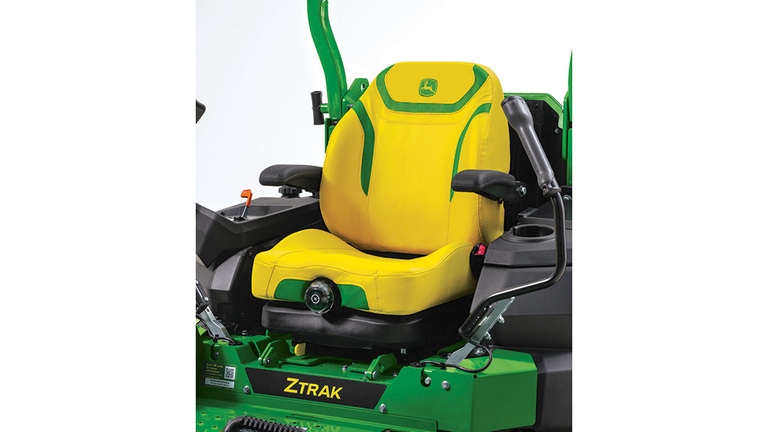 Close-up shot of a yellow ComfortGlide seat with green detailing on a zero-turn mower.