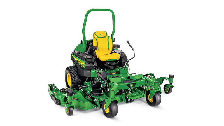 A front-right-facing green zero-turn mower with a yellow seat and green mowing deck on a white background.