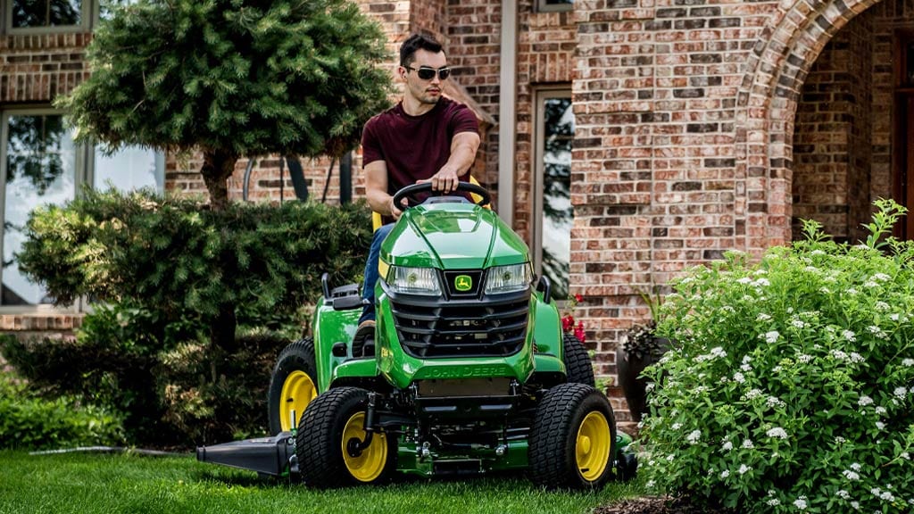 man on x590 lawn tractor in yard