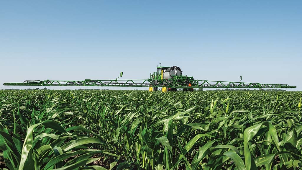 Self-propelled sprayer target spraying in corn field.