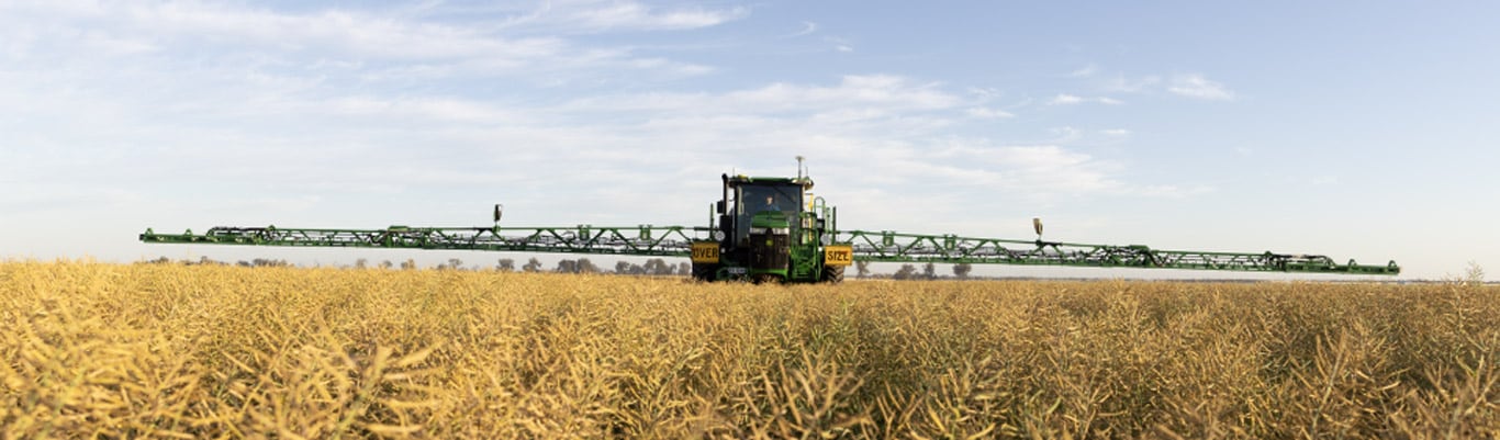 Sprayer with extended boom in a field
