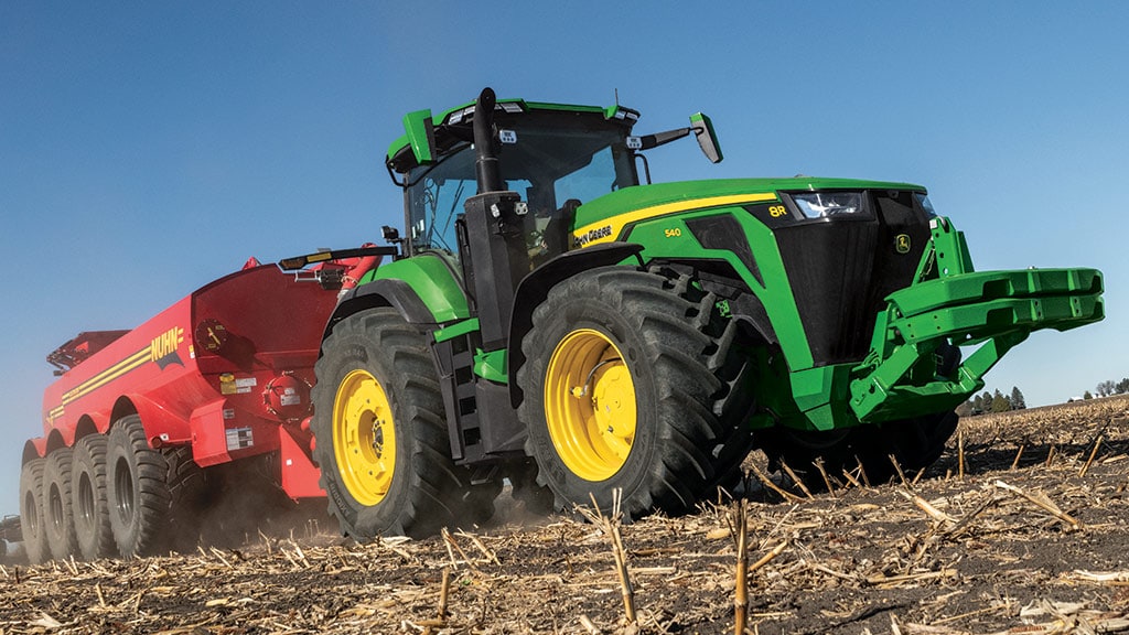 A 8R 540 Tractor using Intelligent Power Management (IPM) to pull a grain cart up an incline