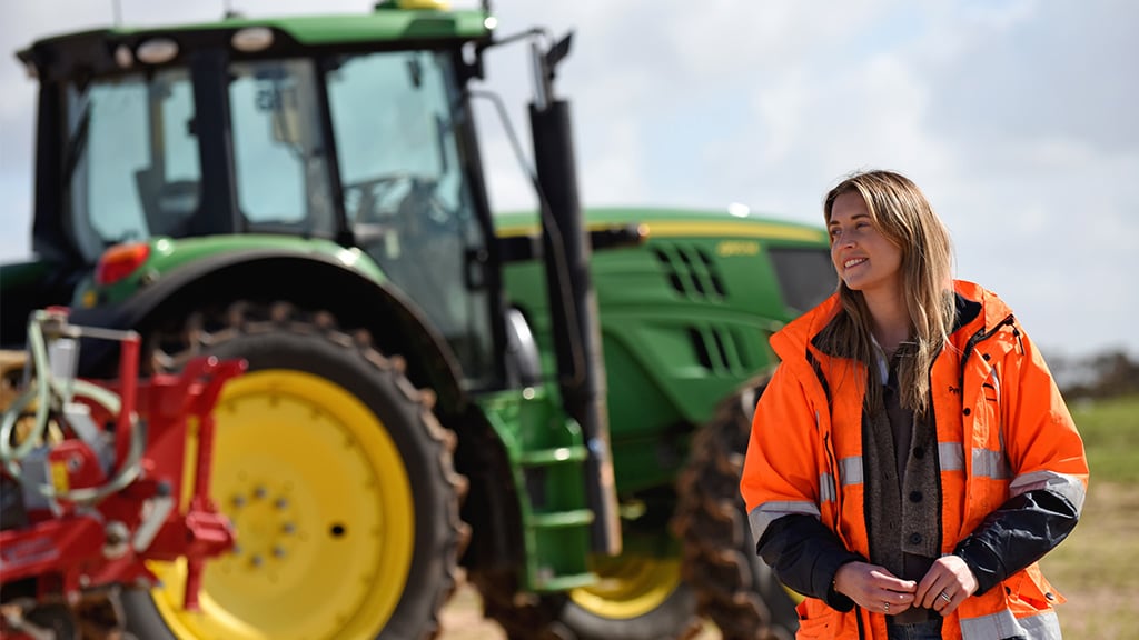 Renae Pye standing in front of John Deere tractor