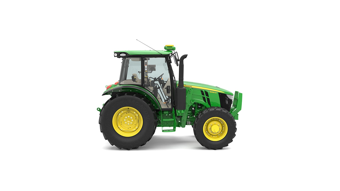 Side view of green and yellow tractor with large tires and enclosed cab on white background.
